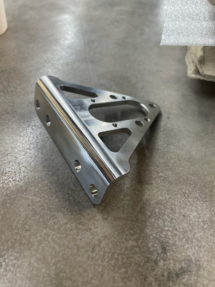 Machined aluminum triangular bracket with pockets and holes